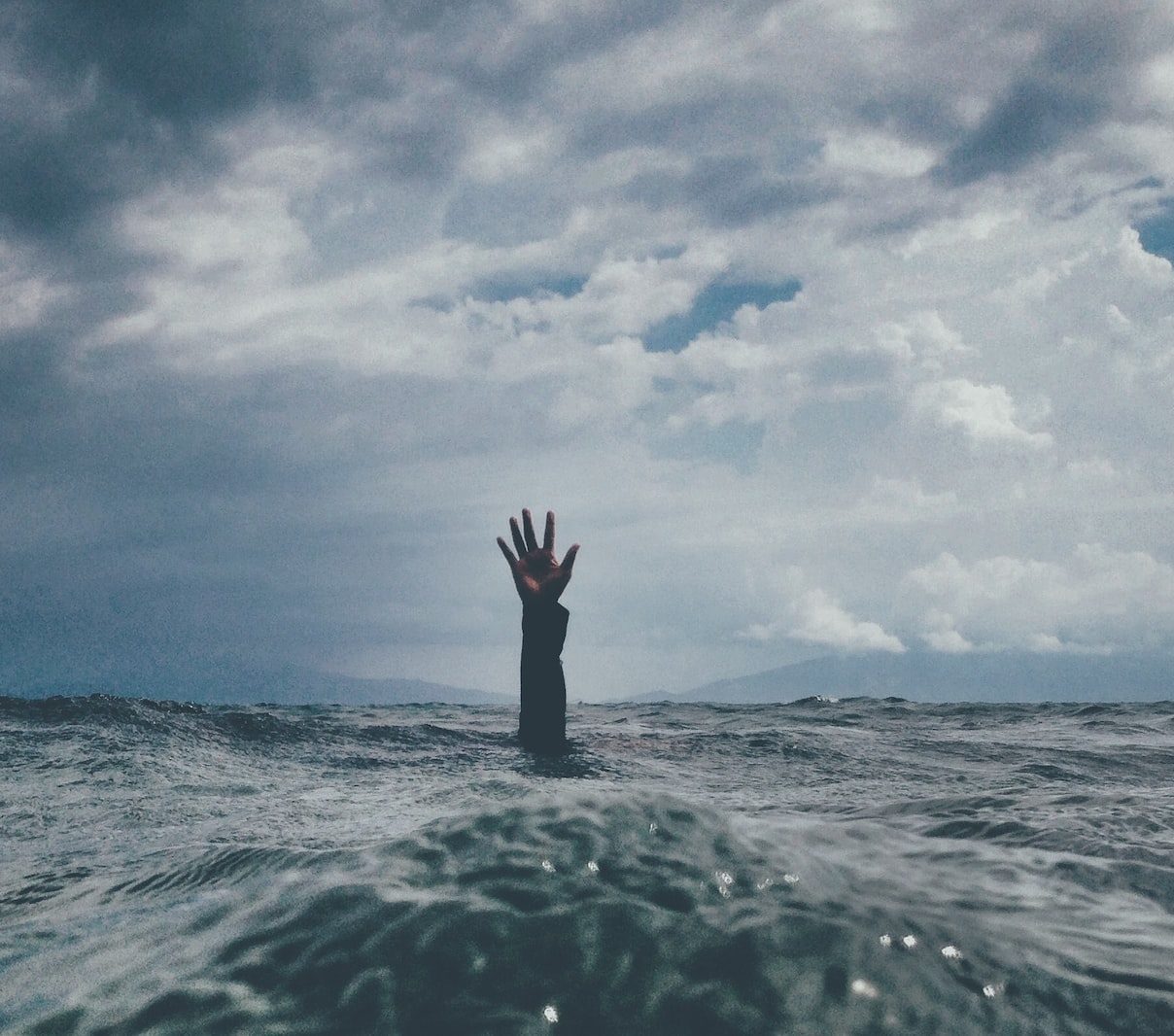 photo of person reach out above the water