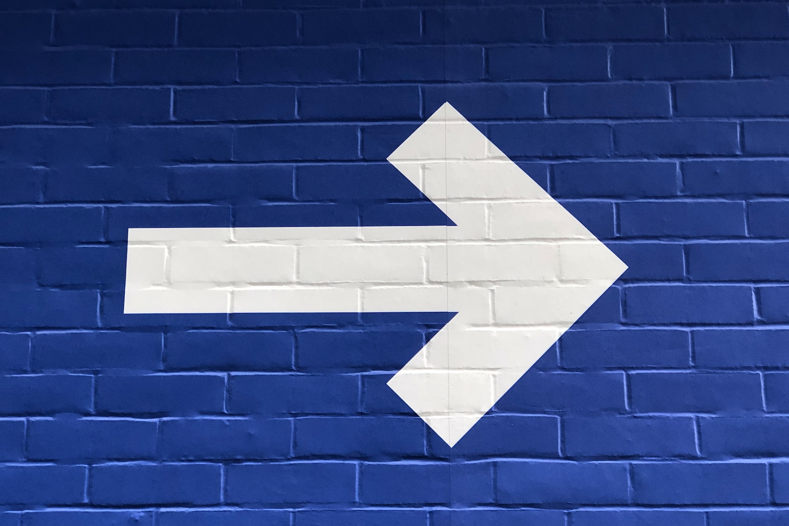 Photo by Nick Fewings white arrow painted on brick wall